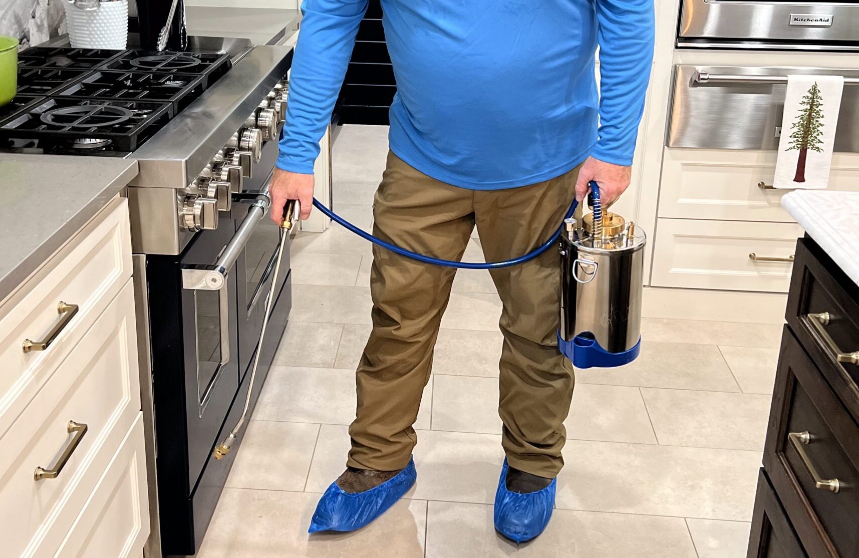 Pest Control Service Technician Spraying in Kitchen